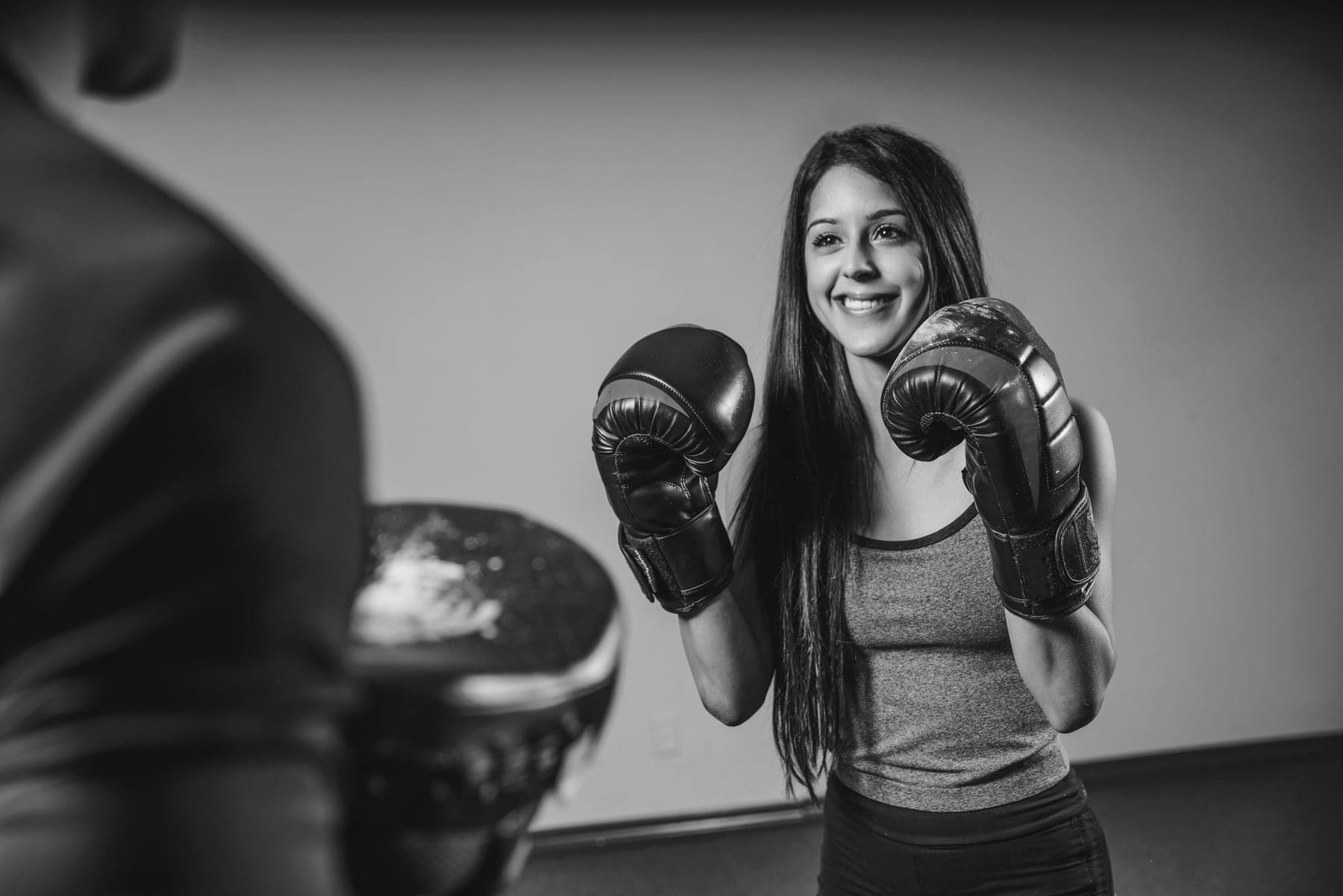 Alumna con guantes de boxeo en guardia, lista para golpear las manoplas