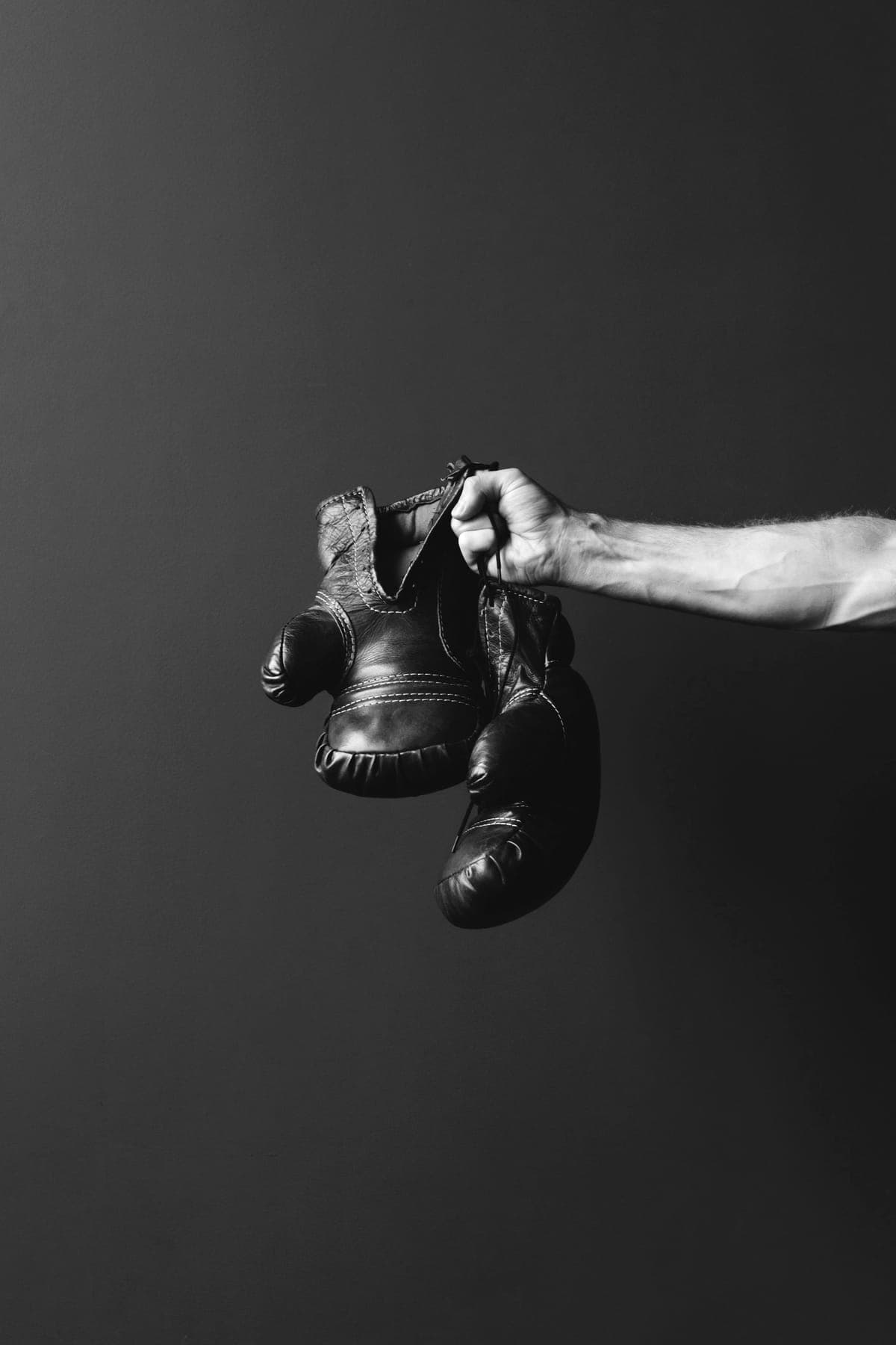 Guantes de boxeo colgando de una mano